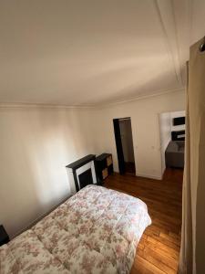 een slaapkamer met een bed in een kamer bij Cosy appartement paris à deux pas in Courbevoie
