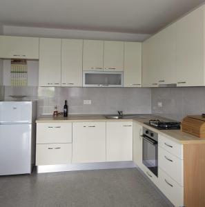 a white kitchen with white cabinets and appliances at Apartment Kate in Stobreč