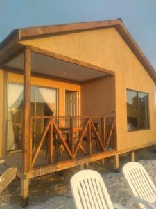 una casa con terraza y 2 sillas en Portofino Surf Camp, en Chañaral