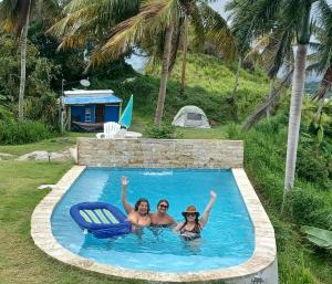 3 Frauen sind im Schwimmbad in der Unterkunft Jubilee Campsite Swim & Paint in Las Piedras