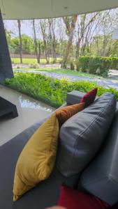 a couch with two pillows and a window at Casa Moneda China in Santa Cruz de la Sierra