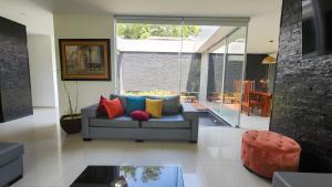 a living room with a couch with colorful pillows at Casa Moneda China in Santa Cruz de la Sierra