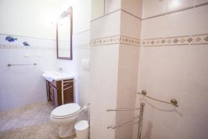 a white bathroom with a toilet and a sink at Appartamento Il Golfo in Portoferraio