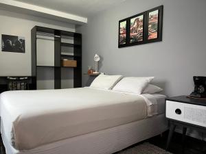 una camera da letto con un grande letto bianco e uno specchio di Sambleña a Cuzco