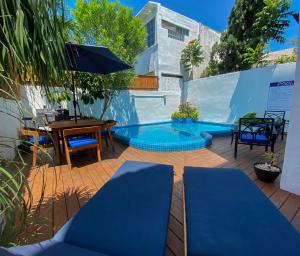 un patio con piscina azul, mesa y sillas en Villa Sofía Holiday Accommodation en Cancún
