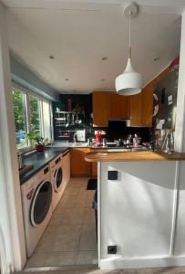 a kitchen with a washing machine and a washer at Appartement jardin à 20 minutes de Paris centre in Le Pecq