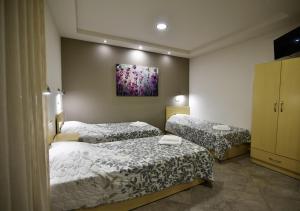 a bedroom with two beds and a painting on the wall at Villa Vayia in Stavros