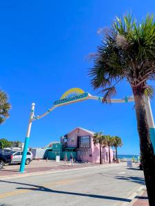 a street sign over a street with a palm tree at Flagler Suites 2 in New Smyrna Beach