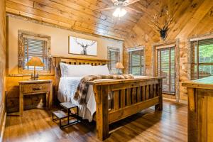 ein Schlafzimmer mit einem Bett in einer Blockhütte in der Unterkunft Stag Horn Lodge in Mineral Bluff