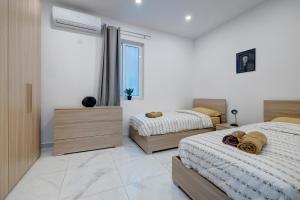 1 dormitorio con 2 camas y ventana en Modern Family Holiday Retreat in Gzira, en Sliema