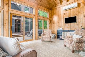 ein Wohnzimmer mit zwei Stühlen und einem Flachbildfernseher in der Unterkunft Stag Horn Lodge in Mineral Bluff