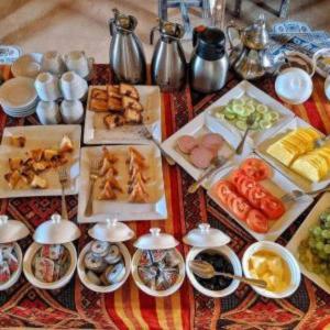 a table with many different types of food on it at Luxury Suerte Camp in Merzouga