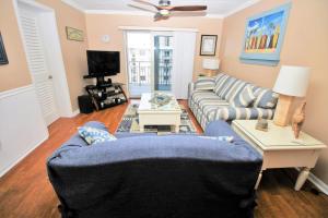 een woonkamer met een blauwe bank en een tv bij Sea Coast Gardens III 514 in New Smyrna Beach