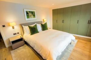 a bedroom with a large white bed with green pillows at The Royal Suite- Harbour Views- Ramsgate in Kent