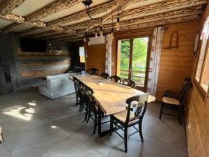 ein Esszimmer mit einem Holztisch und Stühlen in der Unterkunft Chalet Les Sapins sauna au pied des pistes in La Bresse