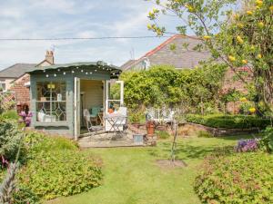um chalé com um jardim e um pátio em Bryn Offa cottage em Holywell
