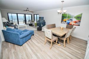 a living room with a table and a blue couch at Shorehom by the Sea 46 in New Smyrna Beach