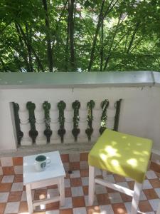 un taburete amarillo y una mesa y una valla en Cricket 2 Hostel, en Belgrado