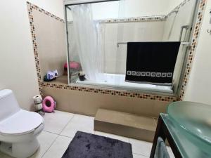 een badkamer met een toilet, een wastafel en een raam bij Acogedora casa en Chihuahua Capital in Chihuahua