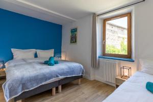 1 dormitorio con 2 camas y pared azul en Domaine du COQ en PAT en Augerolles
