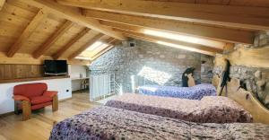 1 dormitorio con 2 camas y pared de piedra en BALLABIO LAKE - Rustic Chic Retreat, en Ballabio