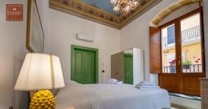 a bedroom with a bed with a green door and a lamp at Dimore Anna Maria -Casa Liberty- in Avola