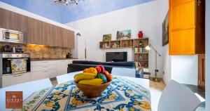 a kitchen with a bowl of fruit on a table at Dimore Anna Maria -Casa Liberty- in Avola