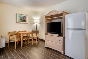 a hotel room with a table and a refrigerator at Tropical Winds Resort Hotel in Daytona Beach