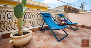 two blue chairs and a plant on a balcony at Dimore Anna Maria -Casa Liberty- in Avola