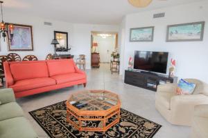 Una sala de estar con un sofá rojo y un televisor. en Mallorca 506, en New Smyrna Beach
