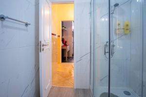 a bathroom with a shower with a glass door at Milena's House in Nazaré