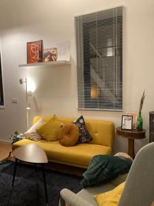 a living room with a yellow couch and a window at Oporto city center charming house in Porto