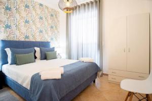 a bedroom with a blue and white bed and a chair at Milena's House in Nazaré