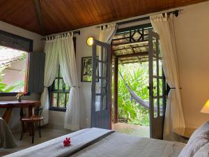 a bedroom with a bed and a door to a patio at Pousada Vila Serrano in Lençóis