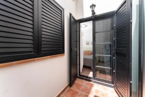 a room with black shutters and a hallway with a door at Doña Juana 4 in Puerto de Mogán
