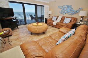 uma sala de estar com um sofá de couro e uma televisão em Southwind 503 em New Smyrna Beach