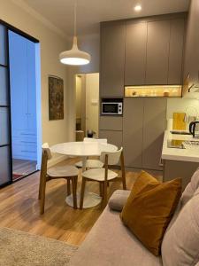 een woonkamer met een tafel en een keuken bij Cozy Urban Retreat in Alma-Ata