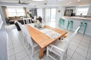 a kitchen and living room with a wooden table and chairs at Oceanwalk 1-501 in New Smyrna Beach