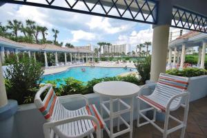 a patio with a table and chairs and a swimming pool at Oceanwalk 1-501 in New Smyrna Beach