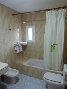 a bathroom with a tub and a toilet and a sink at Hotel Balisa in Níjar