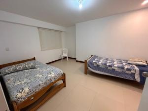 - une chambre avec 2 lits et une chaise dans l'établissement Apartamento Sunset Beach, à San Bartolo