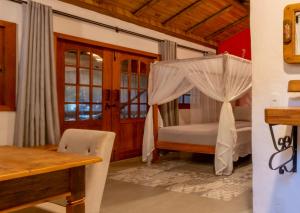 a bedroom with a bed with a canopy and a table at Pousada Vila Serrano in Lençóis