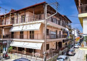 a building with balconies and cars parked on a street at Villa Vayia in Stavros