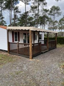 a small white house with a porch with a roof at Mobilhome 3 chambres in Bias