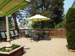 a patio with tables and chairs and an umbrella at Quality Inn Owen Sound in Owen Sound