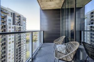 a balcony with chairs and a view of buildings at 2BD Condo-Rainey St-Best views-RT Pool in Austin