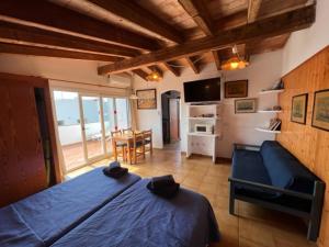 a bedroom with a blue bed and a dining room at Apartamentos Can Marsalet in Portocolom