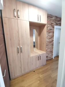 a large wooden cabinet with a mirror in a room at Stan na dan M in Novi Sad