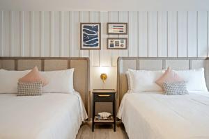 twee bedden naast elkaar in een slaapkamer bij Greyfinch Chatham Inn in Chatham