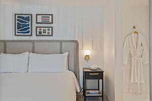 ein Schlafzimmer mit einem Bett und einem Bademantel auf einem Kleiderständer in der Unterkunft Greyfinch Chatham Inn in Chatham